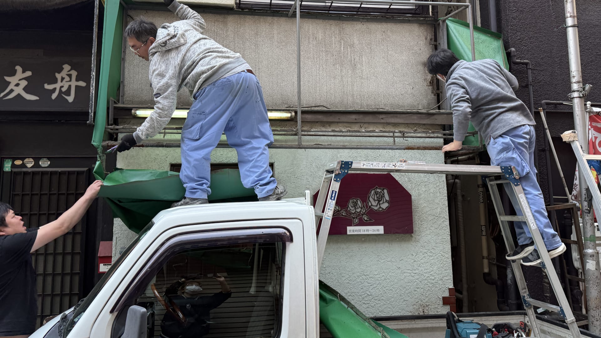テント生地を慎重に剥がす作業風景
